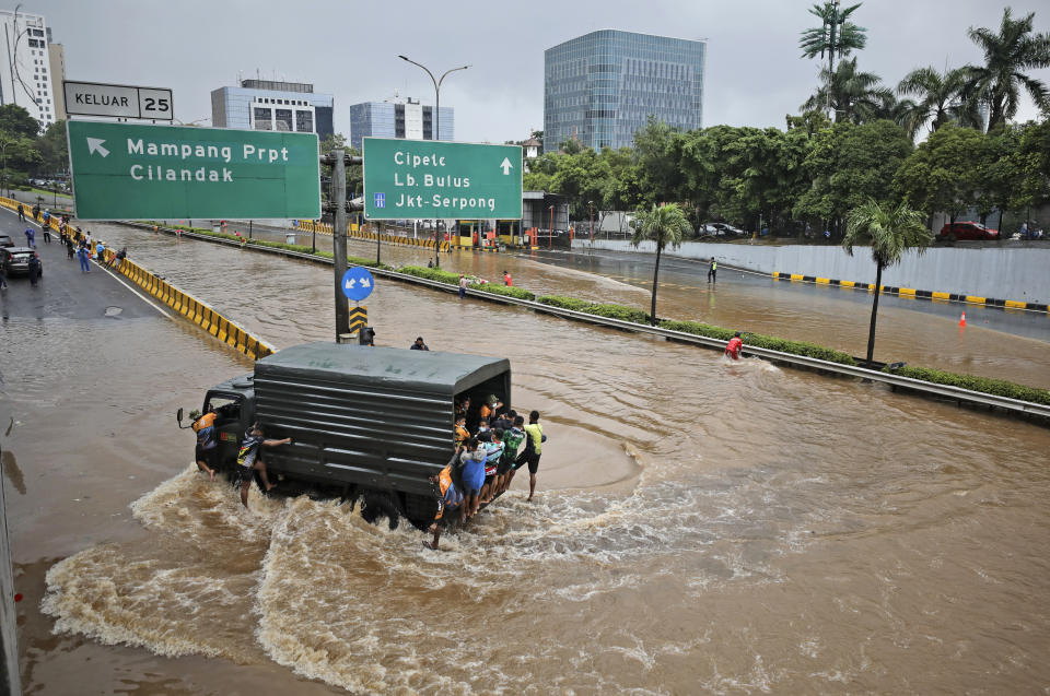 FILE - A military truck drives through the water on a flooded toll road following heavy rains in Jakarta, Indonesia, Saturday, Feb. 20, 2021. Heavy downpours combined with poor city sewage planning often causes heavy flooding in parts of greater Jakarta. Indonesia is planning to move the country’s capital from Jakarta — a city that is sinking below sea level — to Kalimantan. (AP Photo/Dita Alangkara, File)