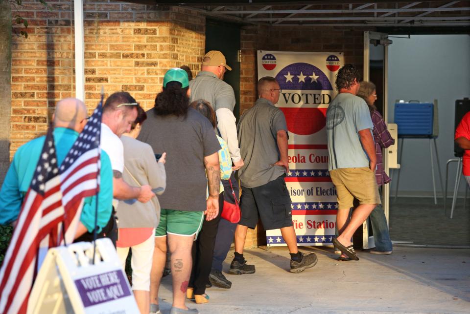 FTSE 100 Voters wait in line to cast their ballots in the midterm elections at a polling station in Kissimmee, Florida on November 8, 2022. (Photo by Gregg Newton / AFP) (Photo by GREGG NEWTON/AFP via Getty Images)