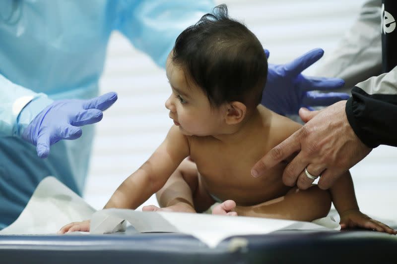 Dr Greg Gulbransen performs a routine checkup with a baby while maintaining visits with both his regular patients and those confirmed to have the coronavirus disease (COVID19) at his pediatric practice in Oyster Bay, New York