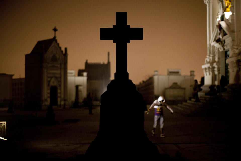 In this Nov.10, 2012 photo, a cross stands in the Presbitero Matias Maestro cemetery during a nighttime guided tour in Lima, Peru. The cemetery, created by one of the last Spanish viceroys, was established the outside the walls of old Lima. There are no more burials anymore at the cemetery unless a family owns a mausoleum. (AP Photo/Rodrigo Abd)