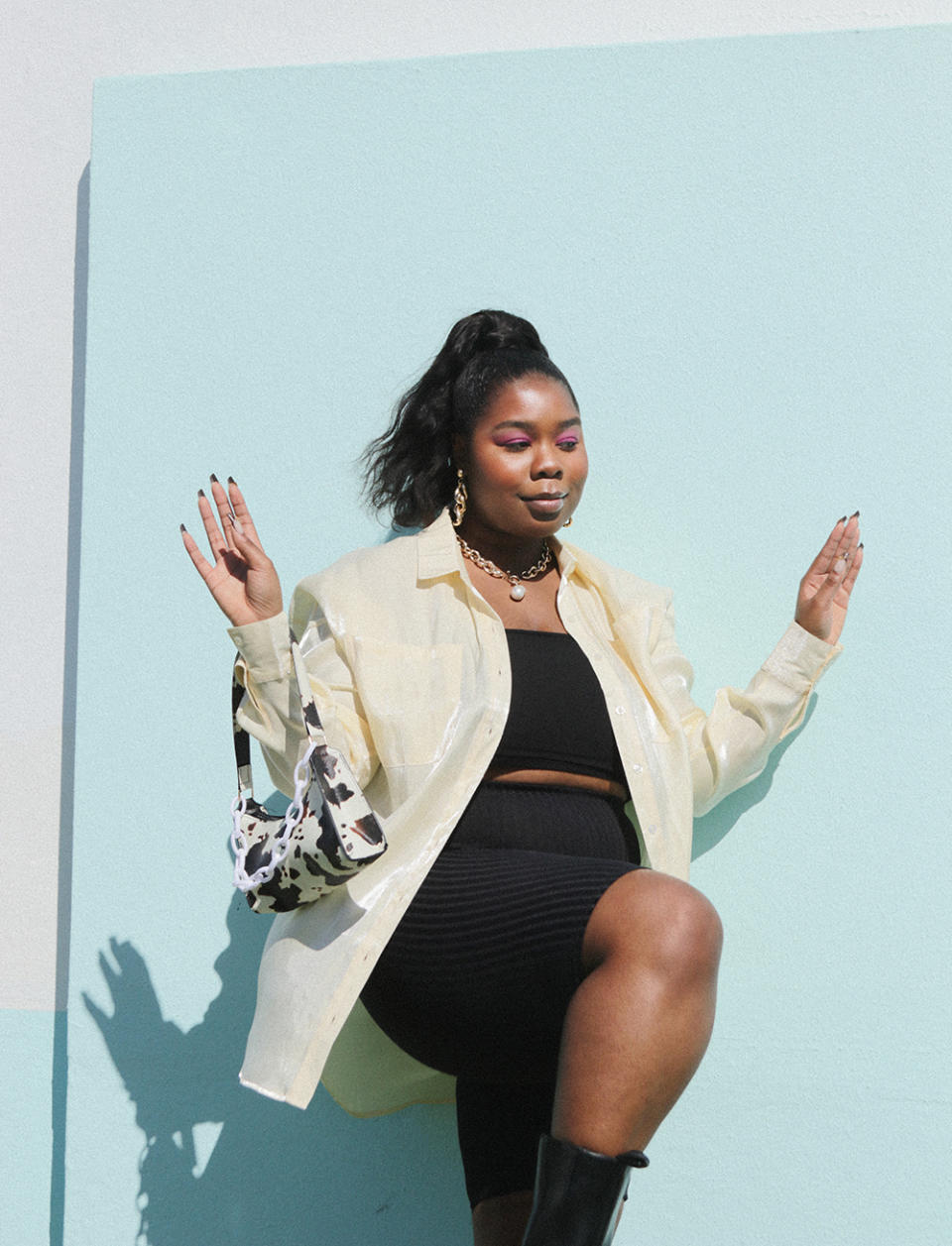 Flex styling the Plus Size Metallic Satin Shirt in lemon (on sale for $42, RRP$84) with black bike shorts and a cow-print bag. Photo: supplied.