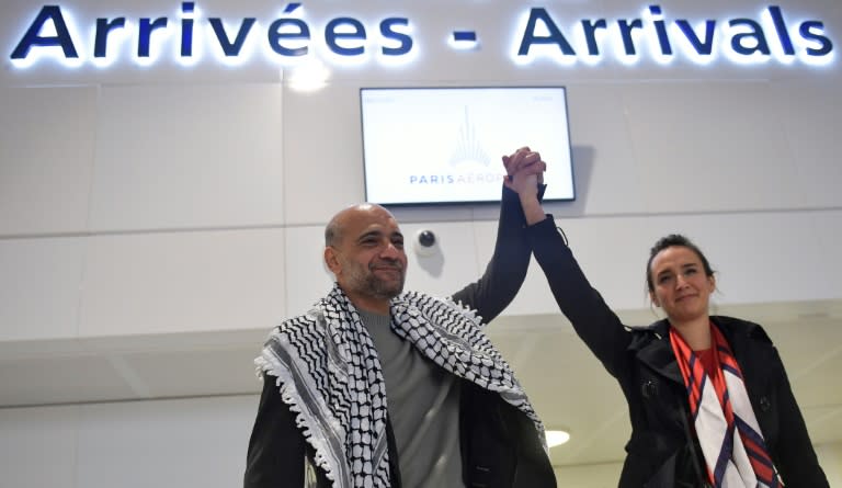 Le militant politique égypto-palestinien Ramy Shaath, avec son épouse Céline Lebrun, à son arrivée à l'aéroport Roissy-Charles de Gaulle après plus de deux ans de détention en Egypte, dans la nuit du 8 au 9 janvier 2022 (AFP/JULIEN DE ROSA)