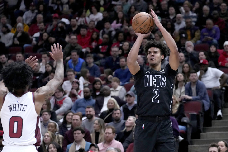 Brooklyn Nets' Cameron Johnson (2) shoots as Chicago Bulls' Coby White defends during the first half of an NBA basketball game Friday, Feb. 24, 2023, in Chicago. (AP Photo/Charles Rex Arbogast)