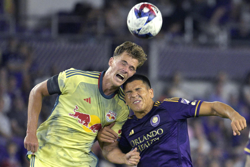 New York Red Bulls forward Tom Barlow, left, and Orlando City midfielder Cesar Araujo compete for a head ball during the first half of an MLS soccer match Saturday, Feb. 25, 2023, in Orlando, Fla. (AP Photo/Phelan M. Ebenhack)