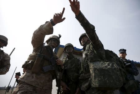 A U.S. (L) marine and South Korean marines participate in a U.S.-South Korea joint landing operation drill in Pohang, South Korea, in this March 31, 2014 file picture. REUTERS/Kim Hong-Ji