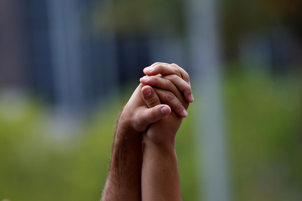 <p>People attend a memorial service the day after a mass shooting at the Pulse gay nightclub in Orlando. (Photo: Carlo Allegri)/Reuters) </p>