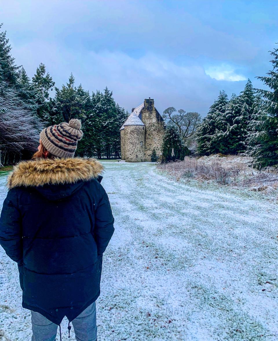 Simon Hunt stands in front of the exterior of Kilmartin Castle on a cold winter day.