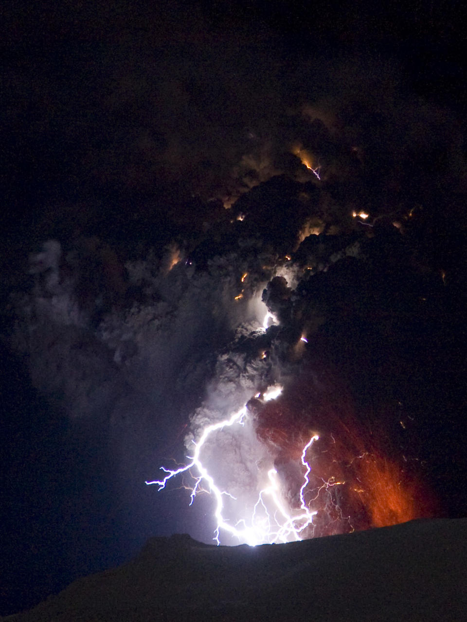 Lighting seen amid the lava and ash erupting from the vent of the Eyjafjallajokull volcano in central Iceland early morning Sunday April 18 2010 as it continues to vent into the skies over Europe. Low-energy lightning is sometimes active during eruptions, arcing between particles as they exit the volcanic vent at around 100 metres per second. The dramatic volcanic eruption which has closed Europe's airspace for days has entered a new phase - producing less smoke but bubbling with lava and throwing up chunks of molten rock. (AP Photo/ Jon Pall Vilhelmsson