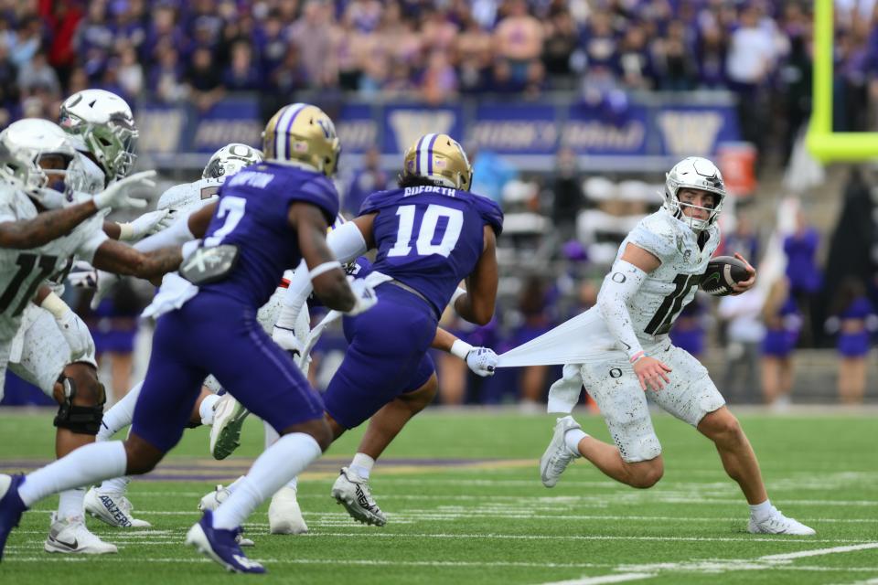 Oregon Ducks quarterback Bo Nix (10) carries the ball against the Washington Huskies during the first half at Alaska Airlines Field at Husky Stadium Oct. 14, 2023, in Seattle.