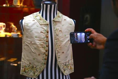 A potential customer takes a photograph of a 250-year-old embroidered silk waistcoat that belonged to Captain James Cook which is on display, at Aalders Auctions house in Sydney, Australia, March 22, 2017. Picture taken March 22, 2017. REUTERS/David Gray