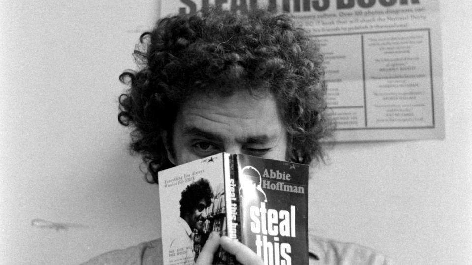 Abbie Hoffman holding a copy of "Steal This Book" in 1971. - John Shearer/The LIFE Picture Collection/Shutterstock