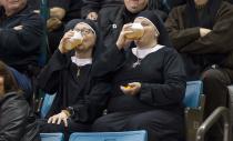 RNPS - REUTERS NEWS PICTURE SERVICE - PICTURES OF THE YEAR 2014 - ODDLY Two women wearing nun outfits drink beer while watching the playoff draw between Quebec and Manitoba at the 2014 Tim Hortons Brier curling championships in Kamloops, British Columbia in this March 8, 2014 file photo. REUTERS/Ben Nelms/Files (CANADA - Tags: SPORT CURLING SOCIETY TPX IMAGES OF THE DAY)