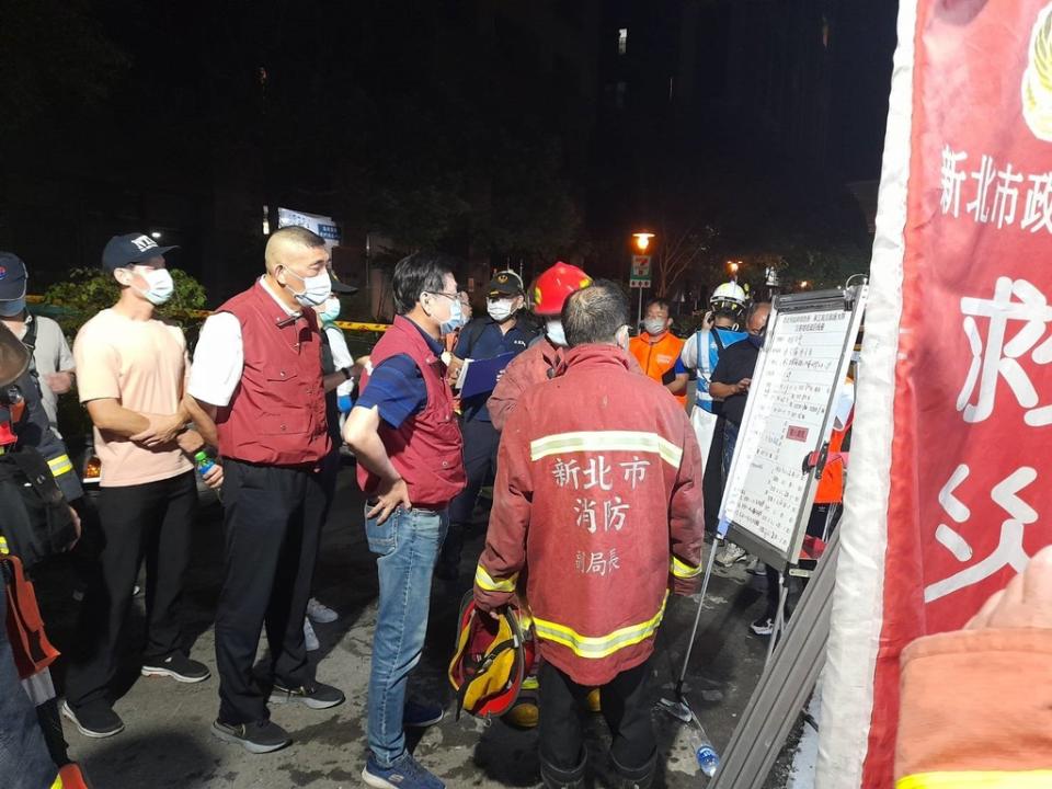 《圖說》劉和然（中）凌晨趕赴火災現場聽取搶救簡報。〈社會局提供〉