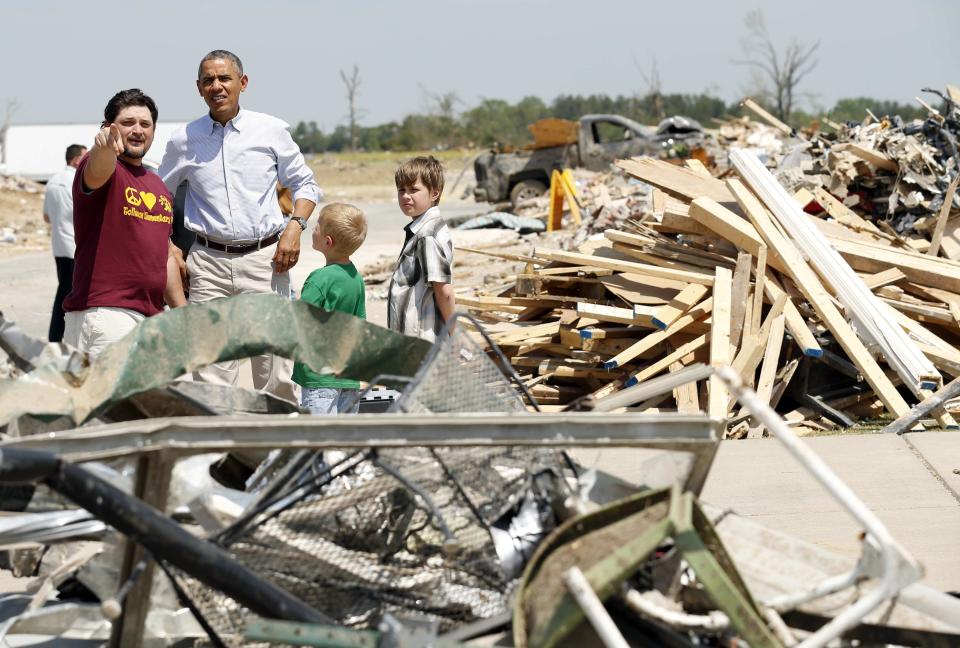 U.S. President Barack Obama talks with Daniel Smith and sons Gabriel Dority (R) and Garrison Dority as he visits the tornado devastated town of Vilonia, Arkansas May 7, 2014. The tornadoes were part of a storm system that blew through the Southern and Midwestern United States earlier this week, killing at least 35 people, including 15 in Arkansas. Obama has already declared a major disaster in Arkansas and ordered federal aid to supplement state and local recovery efforts. (REUTERS/Kevin Lamarque)