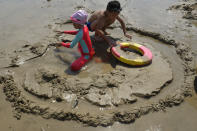 Tourists dig a moat on a beach along the Taiwan Strait in Pingtan in eastern China's Fujian Province, Sunday, Aug. 7, 2022. Taiwan said Saturday that China's military drills appear to simulate an attack on the self-ruled island, after multiple Chinese warships and aircraft crossed the median line of the Taiwan Strait following U.S. House Speaker Nancy Pelosi's visit to Taipei that infuriated Beijing. (AP Photo/Ng Han Guan)