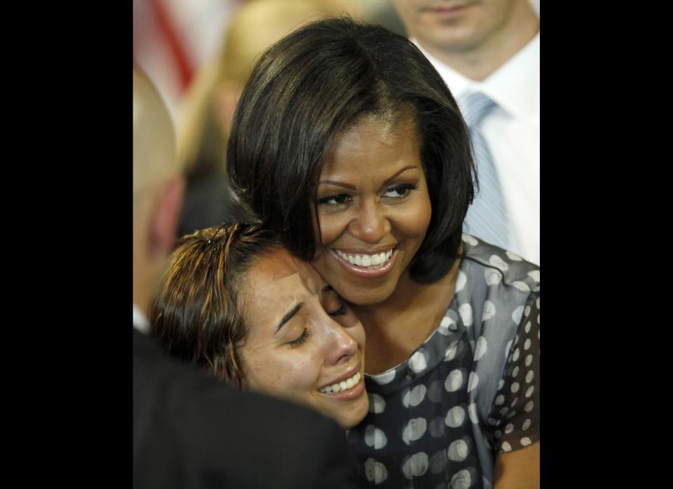 First lady Michelle Obama hugs a woman in the audience after Illinois Gov. Pat Quinn signed into law a measure allowing military personnel and their spouses a quicker transfer of their professional licenses to Illinois during a military relocation, Tuesday, June 26, 2012, in Chicago.