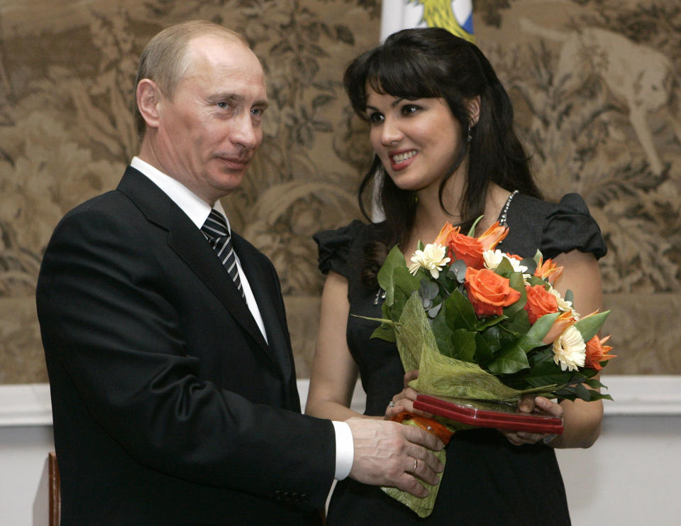 FILE - Russian President Vladimir Putin, left, congratulates Russian opera singer Anna Netrebko after awarding her with the People's Artist of Russia honor, during the 225th anniversary celebrations of the Mariinsky Theater in St. Petersburg, Russia, on Feb. 27, 2008. Netrekbo withdrew from her future engagement at the Metropolitan Opera rather than repudiate her support for Russia President Vladimir Putin, costing the company one of its top singers and best box-office draws. (AP Photo/Dmitry Lovetsky, File)