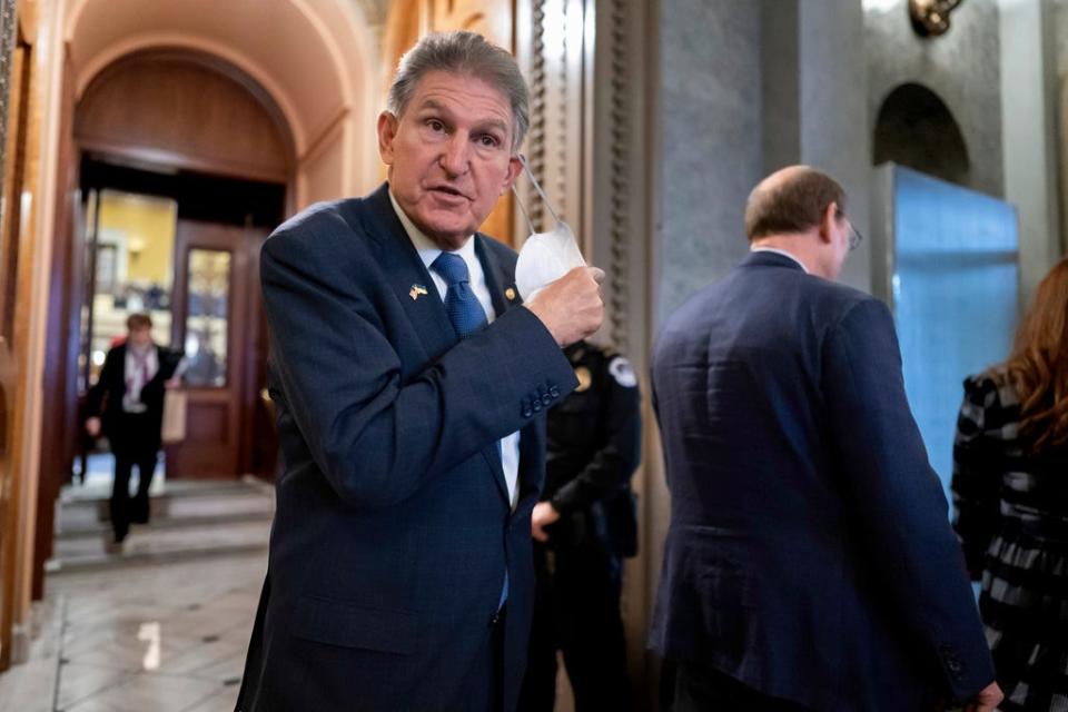 Sen. Joe Manchin, D-W.Va., and other lawmakers leave the chamber at the Capitol in Washington on Dec. 22.