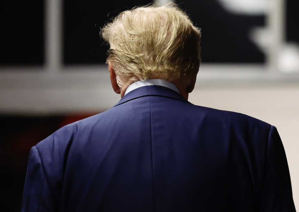 Trump, viewed from behind wearing a dark suit jacket