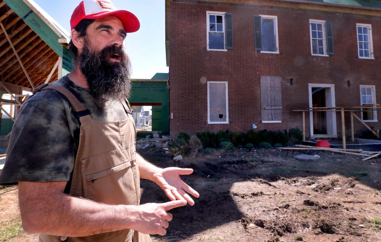 Brandon Urban, stands in front of his home The Corners on Stones River that he owns with his wife, Heather Smith, on Thursday, March 28, 2024, in the Readyville community in Tennessee, nearly a year after their home was severely damaged by a tornado. Urban talks about how so many people from all over came together to help rebuild the community.