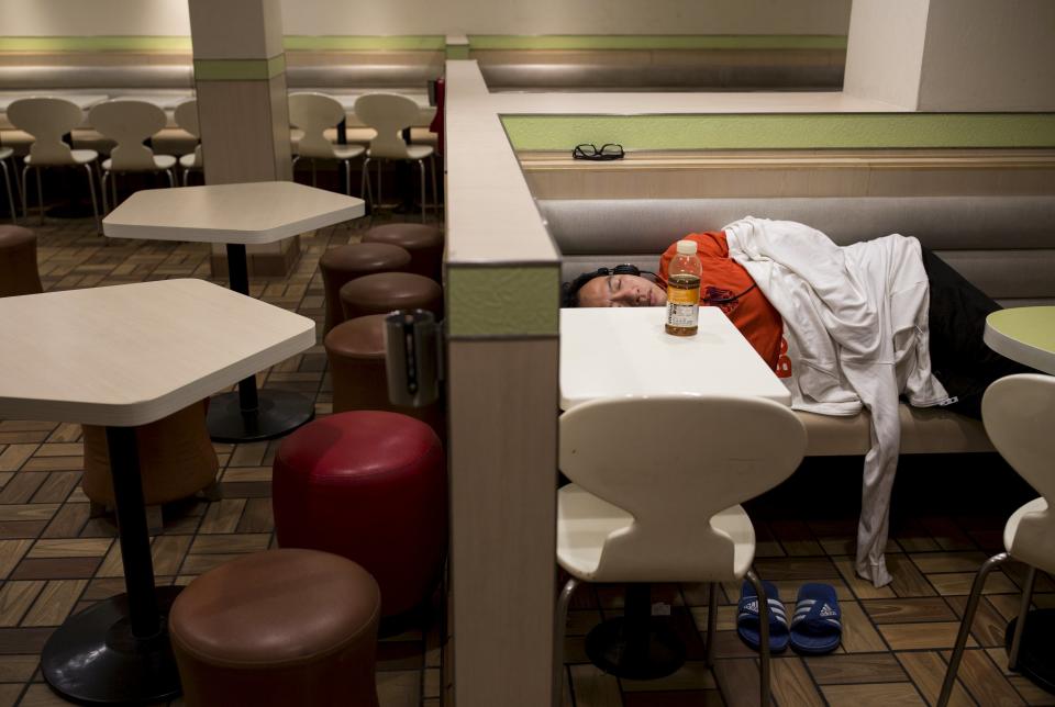 A man sleeps at a 24-hour McDonald's restaurant in Hong Kong, China