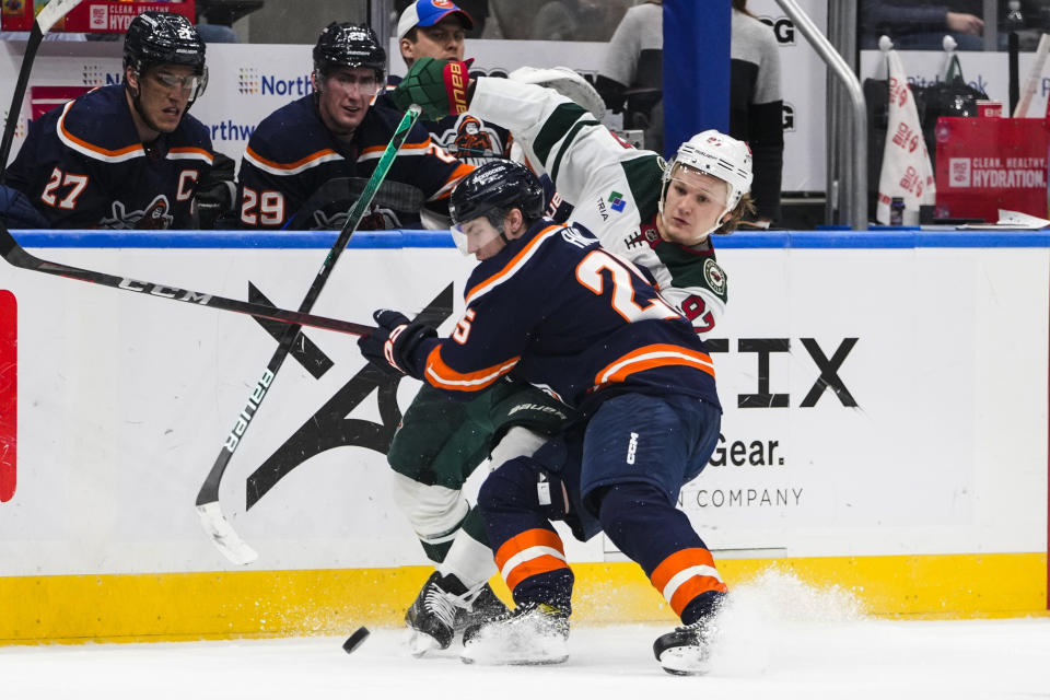 Minnesota Wild's Kirill Kaprizov (97) fights for control of the puck against New York Islanders' Sebastian Aho (25) during the third period of an NHL hockey game Thursday, Jan. 12, 2023, in Elmont, N.Y. The Wild won 3-1. (AP Photo/Frank Franklin II)