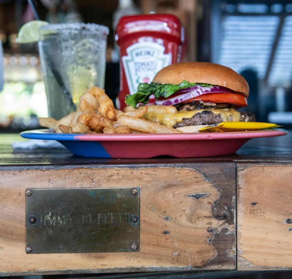 A brass plaque plays on the bar at the Oar House in Pensacola pays homage to the late singer/songwriter Jimmy Buffett.