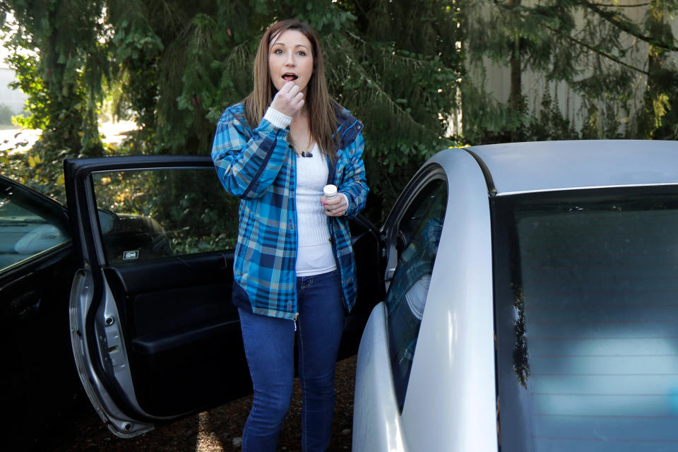 In this Nov. 20, 2019 photo, Jamie Cline takes a dose of a prescription medication called buprenorphine during a break at her job at Genothen, a millwork shop in Tumwater, Wash. The drug quiets a voice in her brain that told her to keep using heroin. (AP Photo/Ted S. Warren)