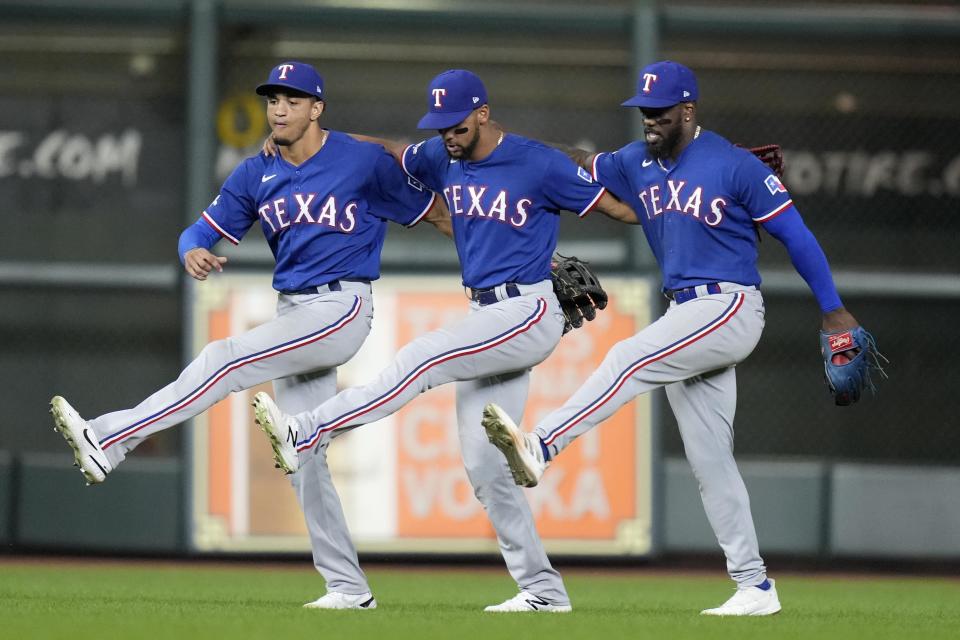 Texas Rangers' Leody Taveras, left, Adolis Garcia, center, and Bubba Thompson celebrates the team's win over the Houston Astros in a baseball game, Tuesday, Sept. 6, 2022, in Houston. (AP Photo/Eric Christian Smith)