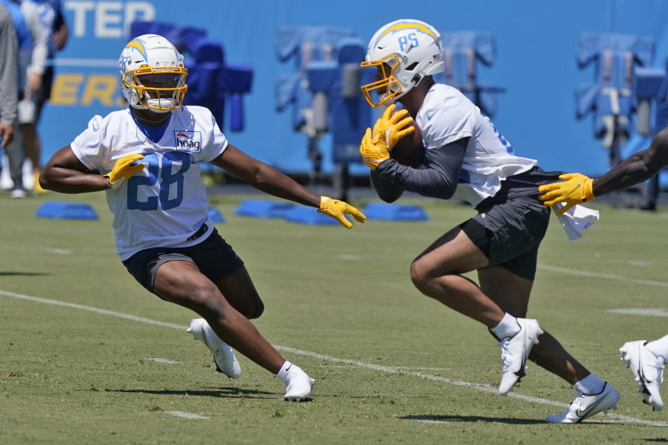 Los Angeles Chargers running back Isaiah Spiller, left, participates in a drill during an NFL football rookie minicamp Friday, May 13, 2022, in Costa Mesa, Calif. (AP Photo/Marcio Jose Sanchez)