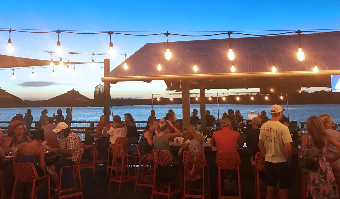 Patrons enjoy the evening air at Hudson’s Seafood House on the Docks.