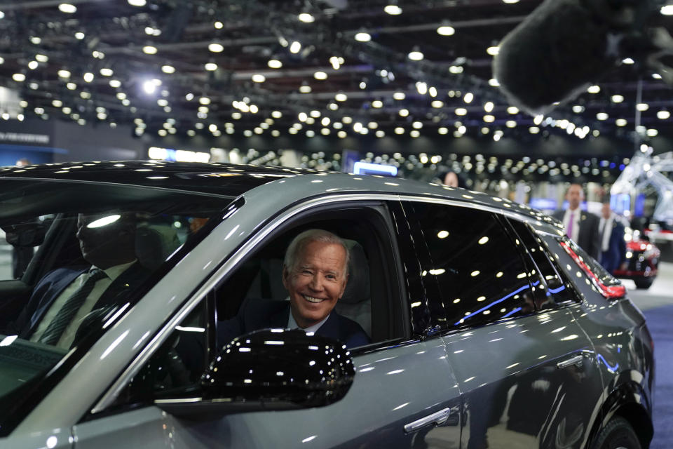 FILE - President Joe Biden drives a Cadillac Lyriq through the showroom during a tour at the Detroit Auto Show, Sept. 14, 2022, in Detroit. With inflation a top concern for voters, many Republican candidates are seeking to capitalize on Americans’ precarious financial situations heading into next week’s midterm elections to vilify a key component of President Joe Biden’s climate agenda: electric vehicles. (AP Photo/Evan Vucci, File)