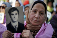 A Lebanese woman holds a picture of her relative who went missing during the Lebanese 1975-90 civil war, during a press conference in front of the U.N. headquarters in Beirut, Lebanon, Wednesday, Nov. 28, 2018. Families of Lebanon's war missing are calling on their government to form a commission expected to look into their relatives' fate nearly three decades after the war ended. (AP Photo/Bilal Hussein)