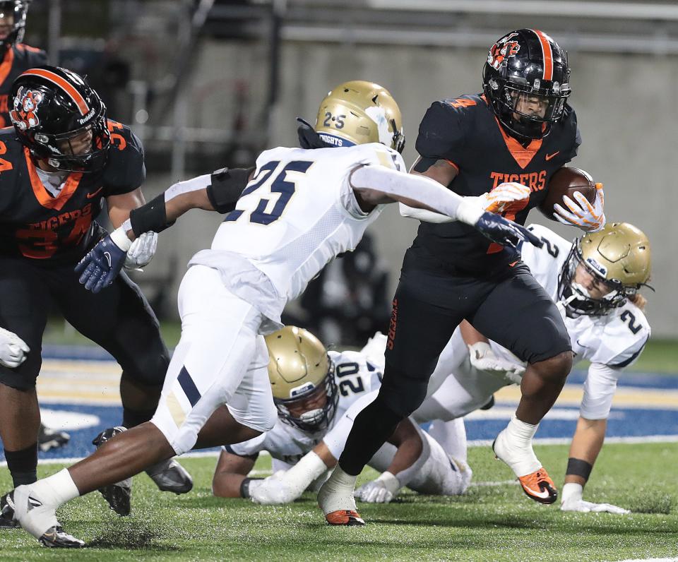 Massillon running back Willtrell Hartson tries to break free from Hoban defenders Caleb Jones, 25, Nick Crawford, 20, and Jayvian Crable, 2, in the second half of an OHSAA Division II state semifinal, Friday, Nov. 25, 2022, at the University of Akron.