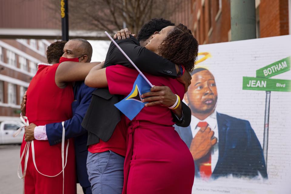 FILE - The family of Botham Jean hug after unveiling the street sign for Botham Jean Boulevard which is named after their slain son and brother in Dallas on Saturday, March 27, 2021. (Juan Figueroa/The Dallas Morning News via AP, File)