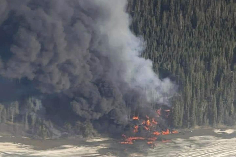 A fire burns after a Douglas C-54 Skymaster plane crashed into the Tanana River outside Fairbanks, Alaska, Tuesday, April 23, 2024. (Michaela Matherne via AP)