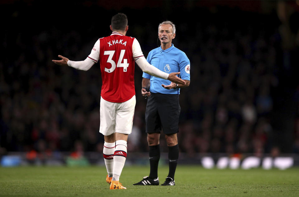 Arsenal's Granit Xhaka speaks to referee Martin Atkinson during the English Premier League soccer match at the Emirates Stadium, London, Sunday Oct. 27, 2019. (Nigel French/PA via AP)