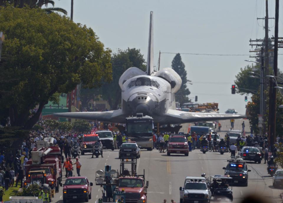 The space shuttle Endeavour is slowly moved down Crenshaw Blvd., Saturday, Oct. 13, 2012, in Los Angeles. The shuttle is on its last mission — a 12-mile creep through city streets. It will move past an eclectic mix of strip malls, mom-and-pop shops, tidy lawns and faded apartment buildings. Its final destination: California Science Center in South Los Angeles where it will be put on display. (AP Photo/Mark J. Terrill)