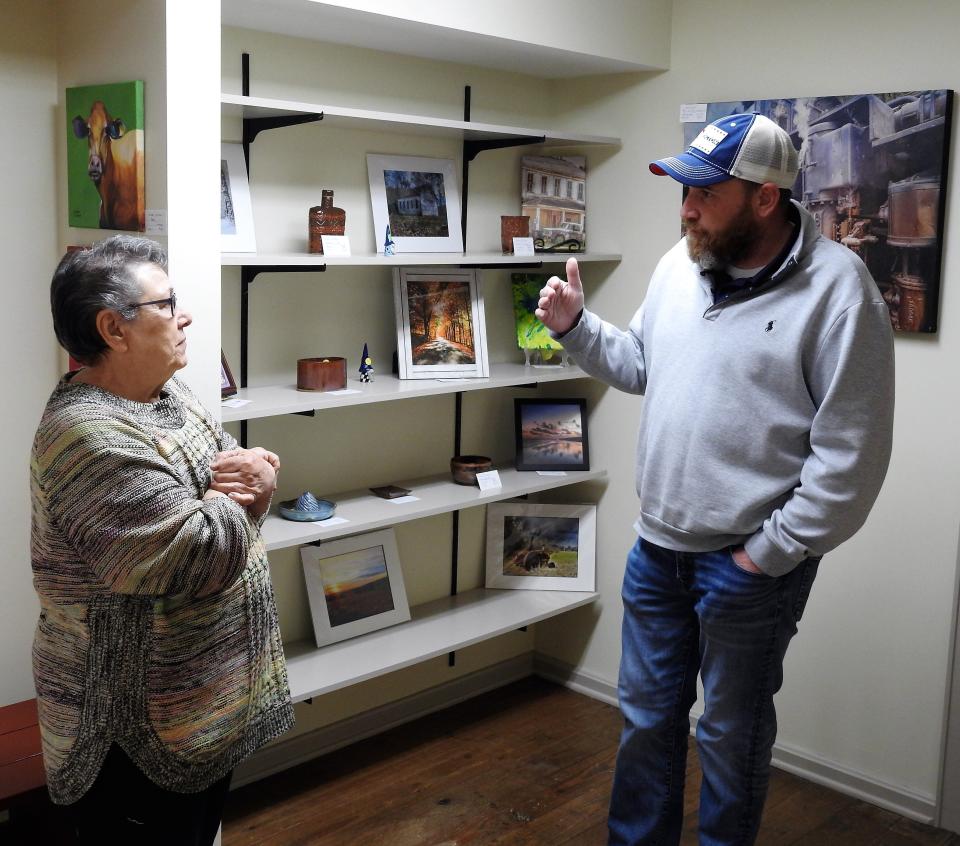 Barbara Hill of the Coshocton Art Guild talks with Mayor Mark Mills at the recent grand opening of an art gallery and gift shop in Roscoe Village.