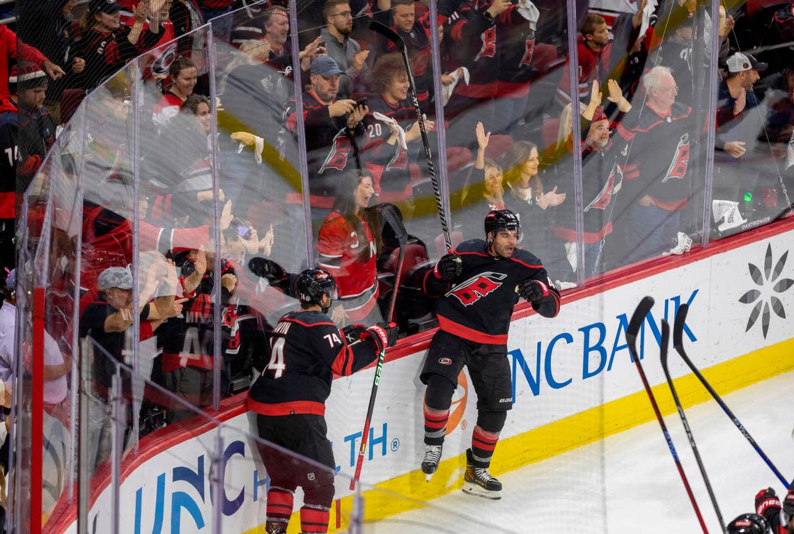 The Carolina Hurricanes Jordan Martinook (48)l and Jaccob Slavin (74) crash the boards as they celebrate their 5-3 victory over Ottawa on Wednesday, October 11, 2023 at PNC Arena, in Raleigh N.C. Robert Willett/rwillett@newsobserver.com