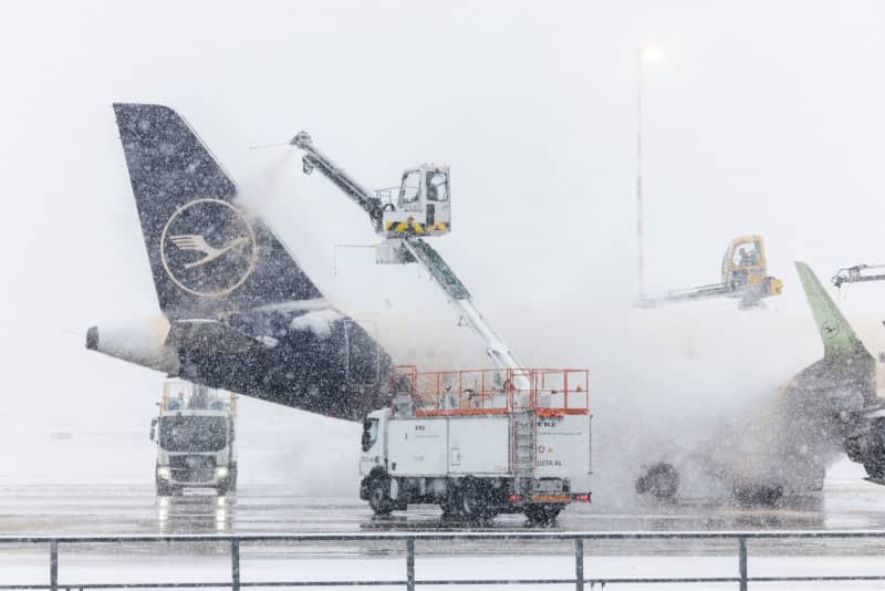 A Lufthansa Airbus A320neo aircraft is de-iced at Frankfurt Airport after many flights were canceled due to bad weather conditions. Lando Hass/dpa