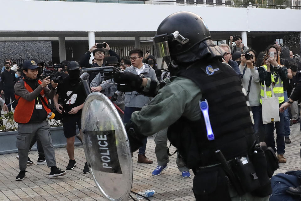 A riot policeman points his gun during a rally to show support for Uighurs and their fight for human rights in Hong Kong, Sunday, Dec. 22, 2019. (AP Photo/Lee Jin-man)