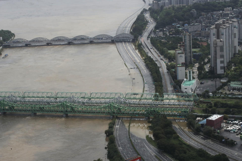 A part of a main road near the Han River is flooded due to heavy rain in Seoul, South Korea, Thursday, Aug. 6, 2020. Torrential rains continuously pounded South Korea on Thursday, prompting authorities to close parts of highways and issue a rare flood alert near a key river bridge in Seoul. (AP Photo/Lee Jin-man)