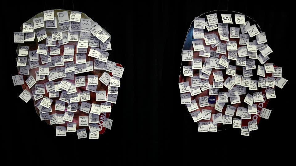 Images of Trump, left, and Florida Gov. Ron DeSantis, right, covered with messages written on sticky notes at the Turning Point Action conference. - Lynne Sladky/AP