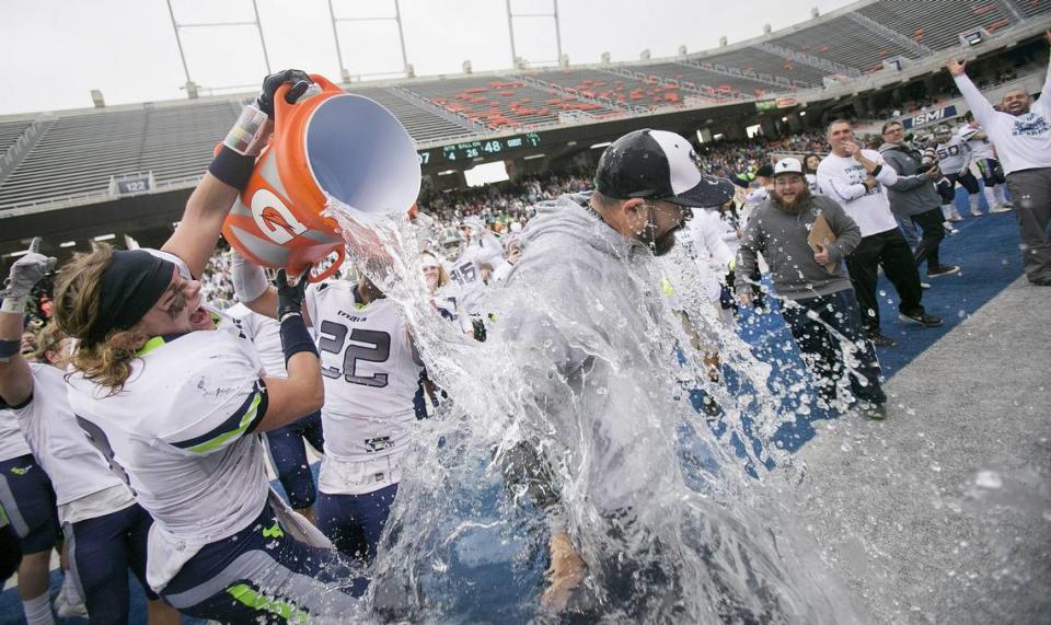 Mountain View coach Judd Benedick (center) gets doused with water by players Khalid Hardy (22) and Erik Haun (8, left) after the 2016 5A championship game against Capital.