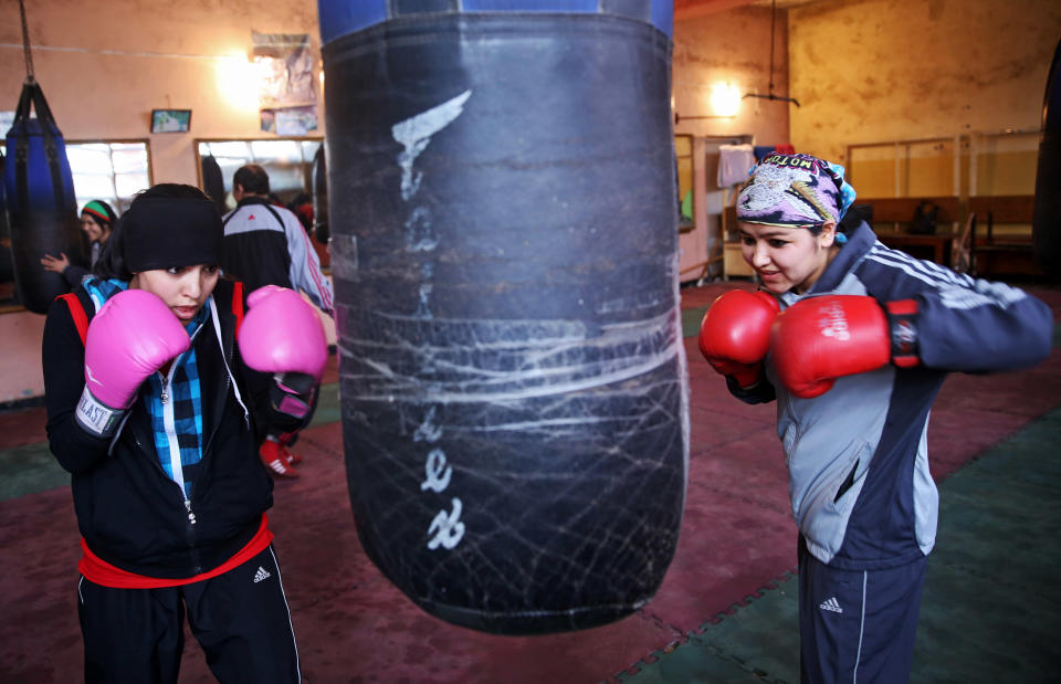 In this Wednesday, March, 5, 2014 photo, Afghan women boxers practice at the Kabul stadium boxing club. A few yellow lamps light up the cavernous, sparsely furnished room where Afghanistan’s young female boxers train, hoping to become good enough to compete in the 2016 Olympics. (AP Photo/Massoud Hossaini)