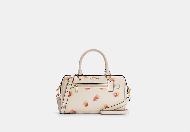 Producto nuevo de Coach Outlet, con estampado floral y detalles dorados