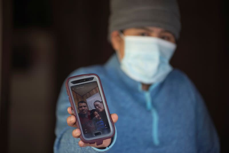Zoila Orozco muestra una foto de ella con su esposo e hijo, mientras el brote de la enfermedad por coronavirus (COVID-19) continúa en Morton, Mississippi, EEUU.