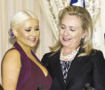 World Food Programme Ambassador singer Christina Aguilera (L) and US Secretary of State Hillary Clinton pose for a photo next to this year's McGovern Awards that were given to Aguilera and David Novak of Yum Brands, for their help fighting global hunger, on October 3, 2012, at the US Department of State in Washington, DC. AFP Photo/Paul J. Richards