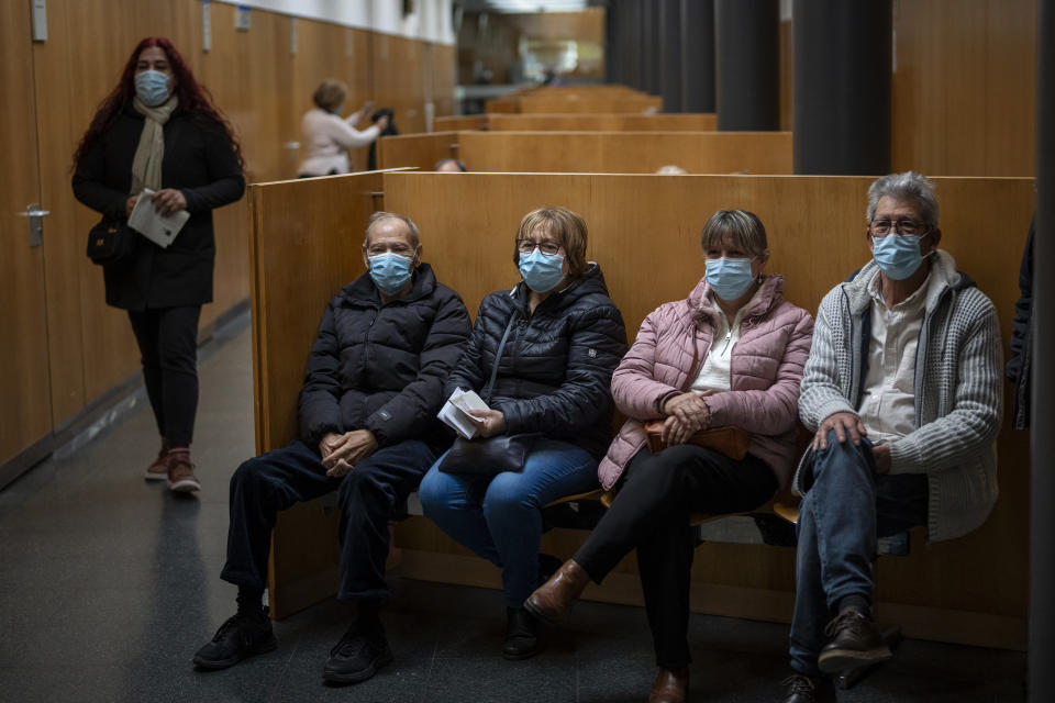 People wearing face masks as a precaution wait for a doctor appointment inside a hospital in Barcelona, Spain, Monday, Jan. 8, 2024. Regional and national health chiefs are meeting Monday to decide whether to extend mandatory mask—wearing to all health facilities following an epidemic outbreak of flu and other respiratory viruses that are putting a strain on the system. (AP Photo/Emilio Morenatti)